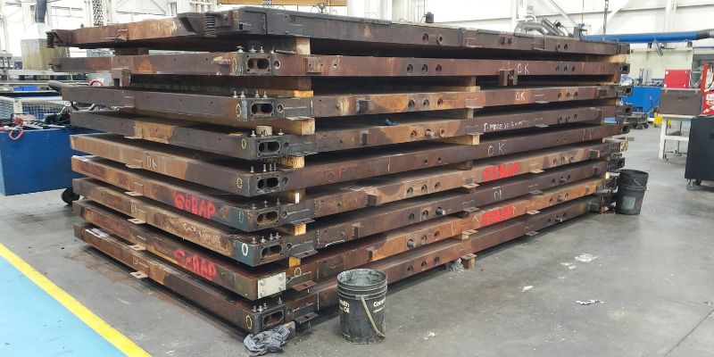 Inspecting platen materials to prepare for refurbishment.